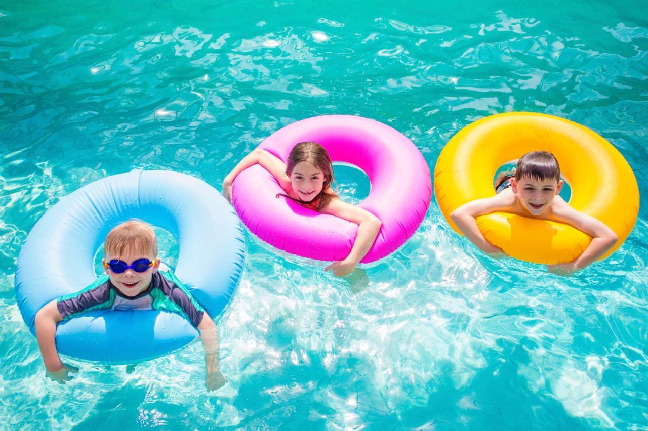 The Act Hotel Szardża Zewnętrze zdjęcie Children using inner tubes in a swimming pool